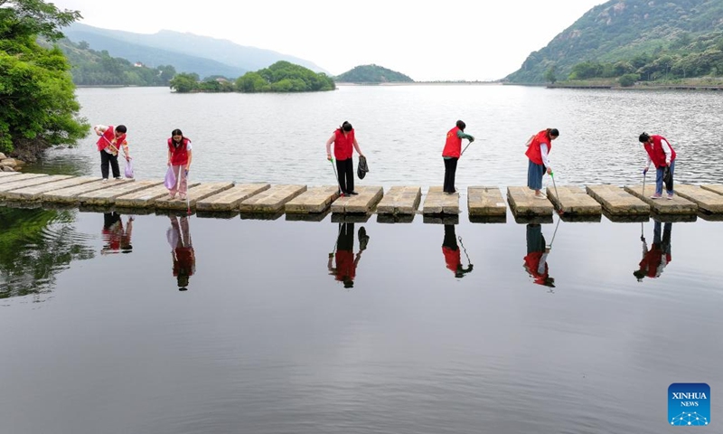 This aerial photo taken on June 5, 2023 shows volunteers picking up garbage at Tangwang Lake in Lianyungang City, east China's Jiangsu Province. The World Environment Day 2023 falls on June 5, focusing on combating plastic pollution. People across China took action to protect the ecological environment in the county.(Photo: Xinhua)