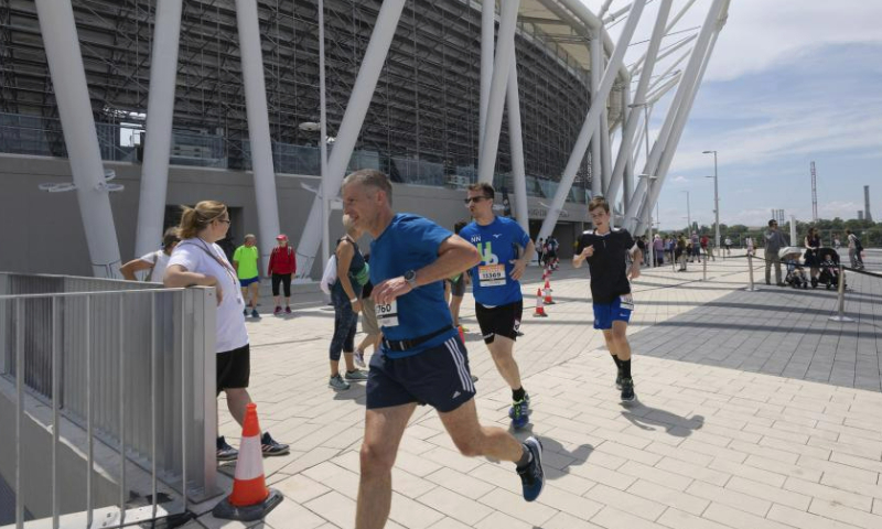 People participate in a running competition during a family day event in the newly opened National Athletics Centre in Budapest, Hungary on June 17, 2023. The brand new National Athletics Centre will host 2023 World Athletics Championships during August 19-27. (Photo by Attila Volgyi/Xinhua)

