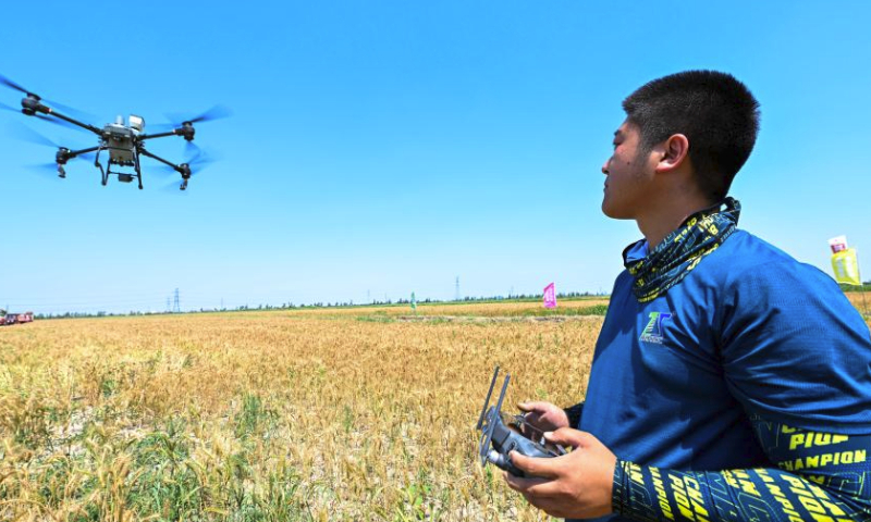A technician operates an unmanned aerial vehicle (UAV) for plant protection during an activity organized by the local goverment to demonstrate agricultural machines in Caigongzhuang Township of Jinghai District, north China's Tianjin, June 11, 2023. Summer harvest in north China's Tianjin has begun. Modern agricultural technology and machinery have been applied in the region to help local farmers increase yield and attain a bumper harvest. (Xinhua/Sun Fanyue)