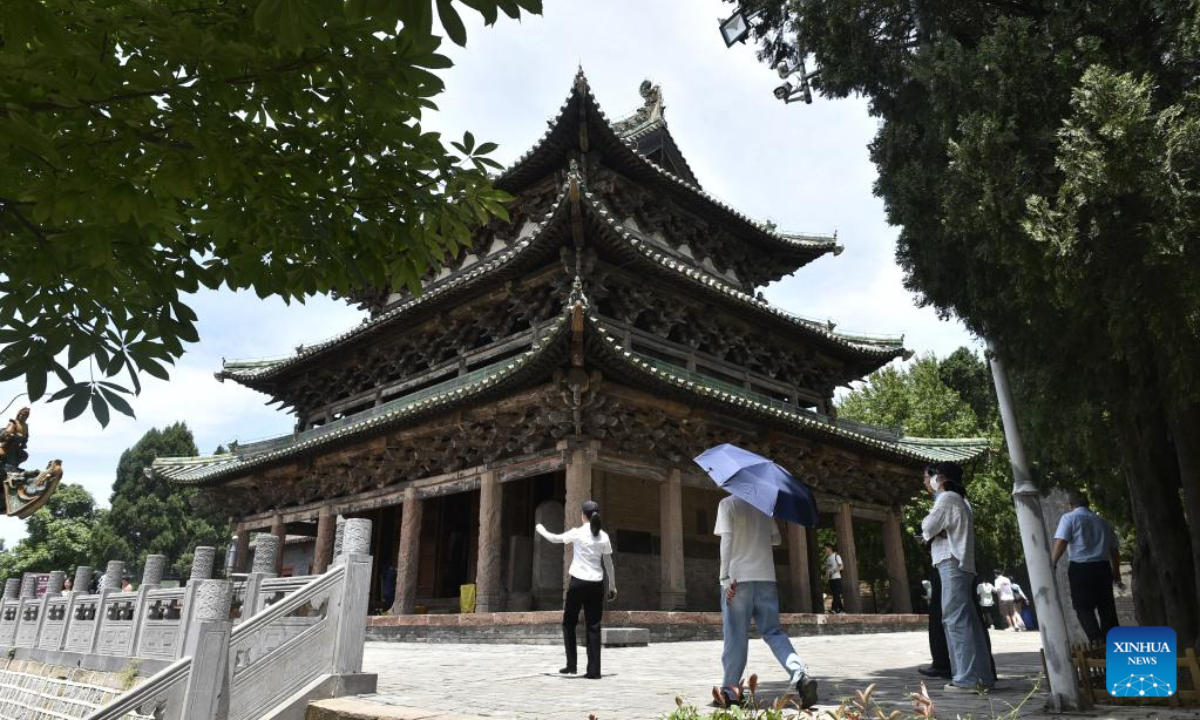 Tourists visit an ancient site in the Wangwu Mountain scenic spot in Jiyuan City, central China's Henan Province, June 15, 2023. Wangwu Mountain is located in Jiyuan City, Henan Province, where the ancient Chinese fable