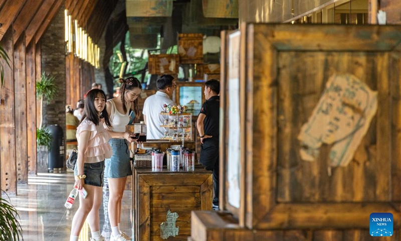 Tourist select souvenir at a cafe of a museum displaying the history of Palace Museum antiques moved there during World War II in southwest China's Chongqing, June 10, 2023. The museum is located in a former foreign firm, where nearly 4,000 cases of antiques were stored during wartime. The items from the Palace Museum, also known as the Forbidden City, were moved to Chongqing in late 1930s when Japanese troops invaded Beijing.(Photo: Xinhua)
