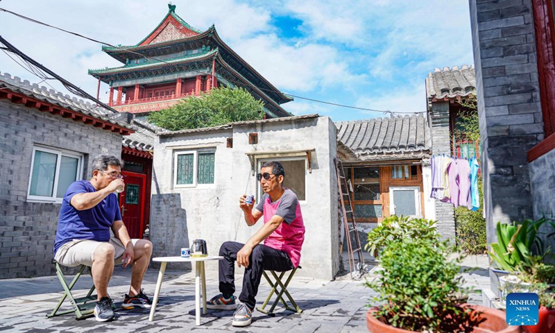 Locals enjoy tea at their courtyard in a hutong near the Drum Tower and Bell Tower in Beijing, capital of China, June 12, 2023. First created in the Yuan Dynasty (1271-1368), the Beijing Central Axis, or Zhongzhouxian, stretches 7.8 kilometers between the Yongding Gate (Yongdingmen) in the south of the city and the Drum Tower and Bell Tower in the north.(Photo: Xinhua)