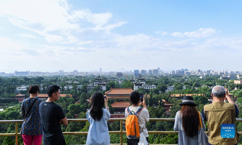 People take photos in Jingshan Park near the Forbidden City in Beijing, capital of China, June 8, 2023. First created in the Yuan Dynasty (1271-1368), the Beijing Central Axis, or Zhongzhouxian, stretches 7.8 kilometers between the Yongding Gate (Yongdingmen) in the south of the city and the Drum Tower and Bell Tower in the north. Most of the major old-city buildings of Beijing sit along this axis.(Photo: Xinhua)