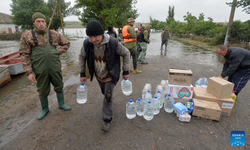 People receive life supplies in Afanasiyivka, Mykolaiv region, June 12, 2023. The Kakhovka hydroelectric power plant was destroyed on June 6, causing a decrease of the dam water level and massive flooding in nearby areas.(Photo: Xinhua)