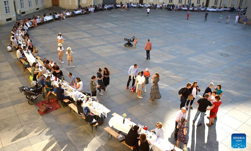 People take part in a long table event at Prague Castle in Prague, the Czech Republic, on June 12, 2023. A roughly 400-meter-long table in the shape of a heart was set up around St. Vitus Cathedral at Prague Castle on Monday. Prague's residents and visitors were welcomed to join the event with their own dishes and share with others.(Photo: Xinhua)