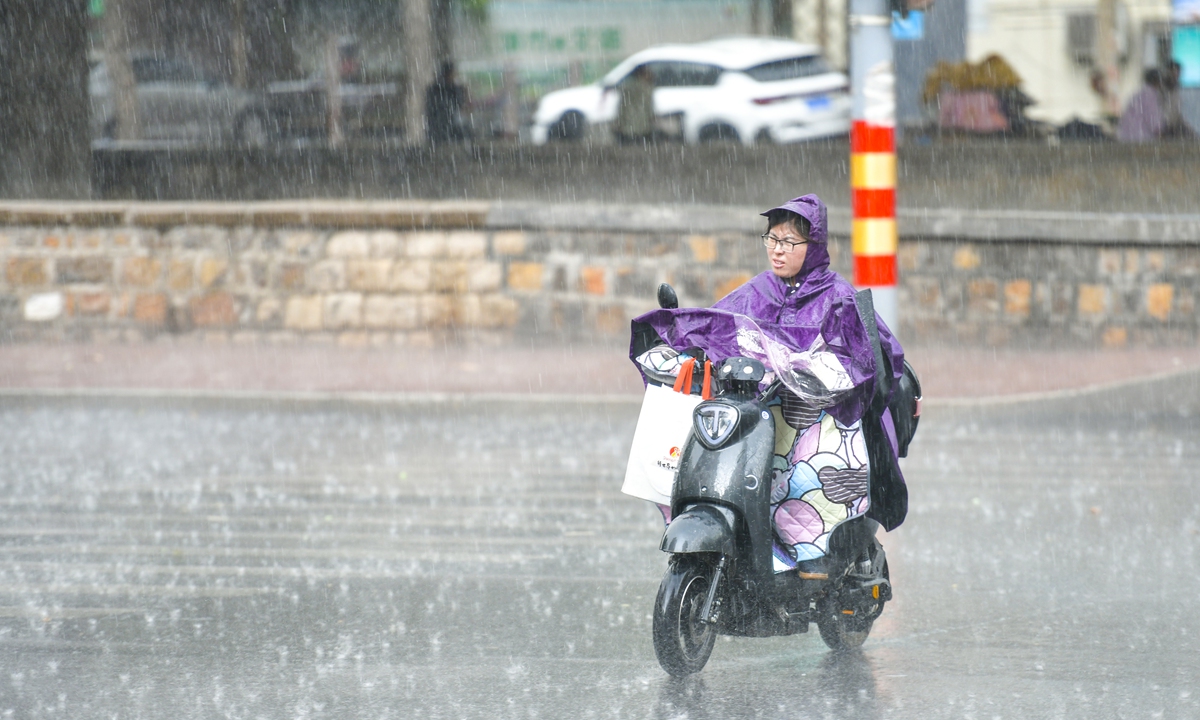 A woman rides an e-bike in rain in Jinan, East China's Shandong Province on June 11, 2023. Photo: IC