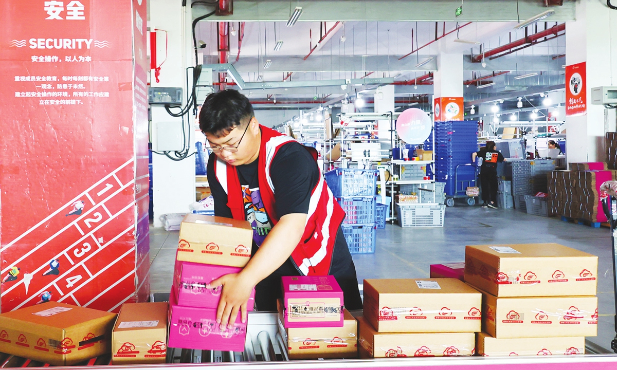 Deliverymen sort packages in an e-commerce industrial zone in Lianyungang, East China's Jiangsu Province, on June 12, 2023. Photo: VCG