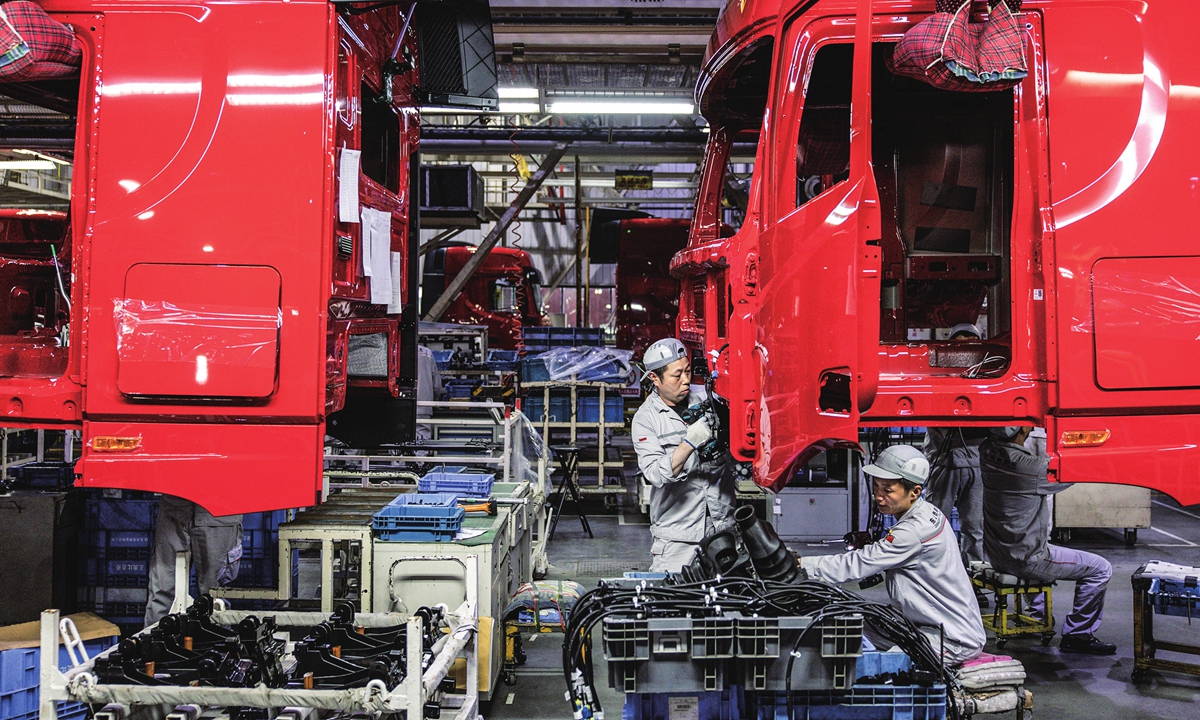 Right: Workshop staff check the newly assembled vehicles in Shiyan, a city known for its motor production. Photo: IC