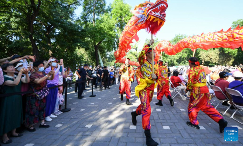 People enjoy a dragon dance performance at Longtan Park in Beijing, capital of China, June 22, 2023. A series of activities including boat races, performances, interactive games were held during the Dragon Boat Festival here. (Xinhua/Ju Huanzong)