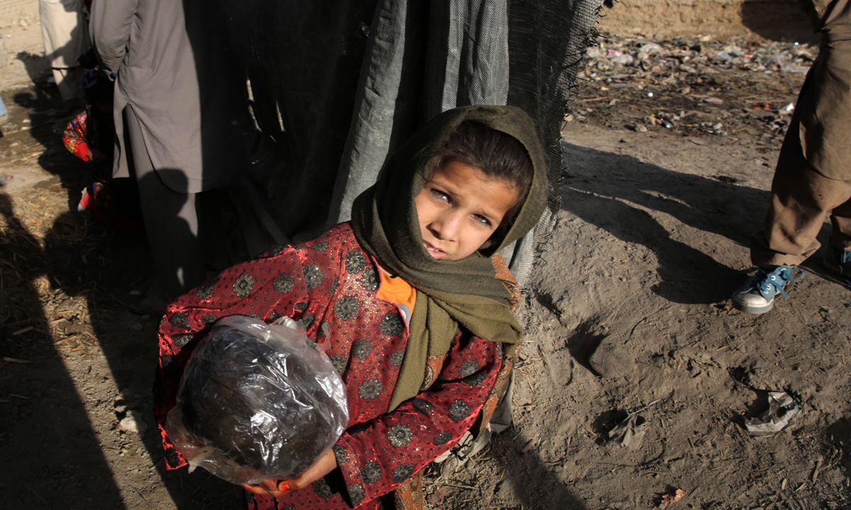 A girl carries garbage in a shantytown on the outskirts of Kabul, Afghanistan, in September, 2021.Photo: IC
