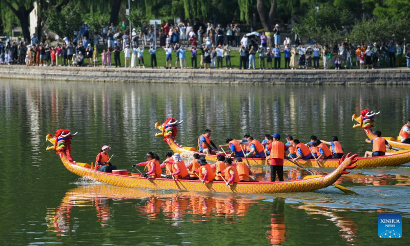 People watch a dragon boat race at Longtan Park in Beijing, capital of China, June 22, 2023. A series of activities including boat races, performances, interactive games were held during the Dragon Boat Festival here. (Xinhua/Ju Huanzong)