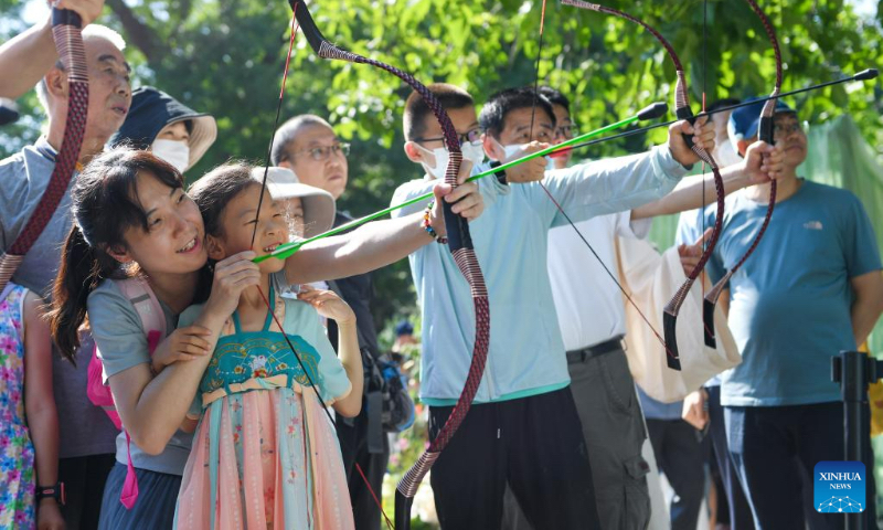 Children and parents take part in a traditional sport game at Longtan Park in Beijing, capital of China, June 22, 2023. A series of activities including boat races, performances, interactive games were held during the Dragon Boat Festival here. (Xinhua/Ju Huanzong)