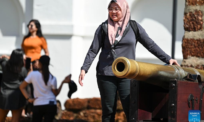 A tourist poses for photos with a cannon at the Porta De Santiago in Malacca, Malaysia, June 18, 2023. Malacca, located on the northern shore of the Strait of Malacca, is a historic city and capital of the state of Malacca.(Photo: Xinhua)