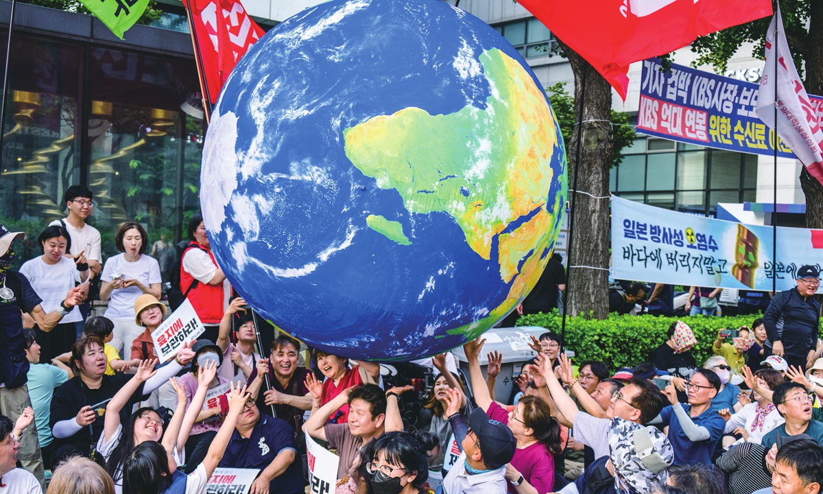 Lifting a miniature globe, activists gather in Seoul to protest against Japan's planned dumping of nuclear-contaminated wastewater from the Fukushima nuclear power plant on June 24, 2023. Photo: AFP