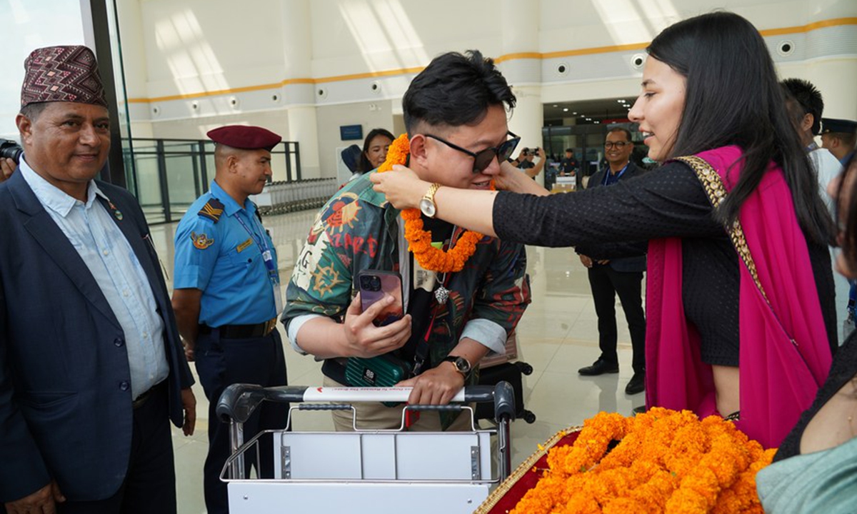 A passenger aboard a Sichuan Airlines charter flight is welcomed with a garland after arriving at the Pokhara International Airport in Pokhara, Nepal, June 21, 2023.(Photo by Hari Maharjan/Xinhua)

