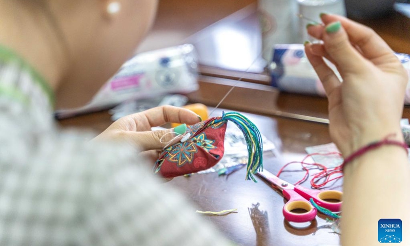 A person makes a sachet to celebrate the Dragon Boat Festival in Vladivostok, Russia, June 22, 2023. The Confucius Institute of the Russian Far Eastern Federal University organized cultural activities on the occasion of the China's Dragon Boat Festival. (Photo by Guo Feizhou/Xinhua)