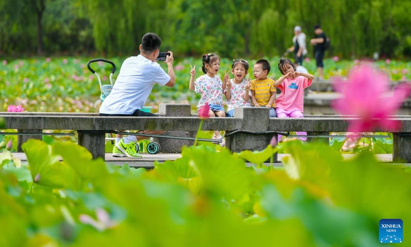 Children pose for a group photo at the Xianshanhu scenic area in Changxing County of Huzhou City, east China's Zhejiang Province, June 23, 2023. People go out for various activities during the three-day Dragon Boat Festival holiday across the country. (Photo by Tan Yunfeng/Xinhua)