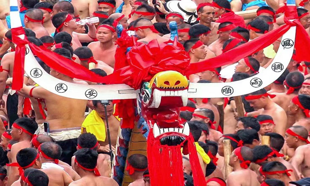 In Southwest China's Guizhou Province, thousands of young men carry the world's longest dragon boat, measuring 98.8 meters, and row it down the river in a spectacular and awe-inspiring atmosphere. Photo: Star Video