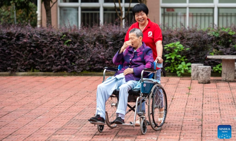 A staff member takes care of a senior resident in a wheelchair at a social welfare center in Hanshou County of Changde City, central China's Hunan Province, June 20, 2023.The city of Changde has scaled up efforts to develop an elderly care service system composed mainly of in-home cares, community services, institutional and medical cares. (Xinhua/Chen Sihan)