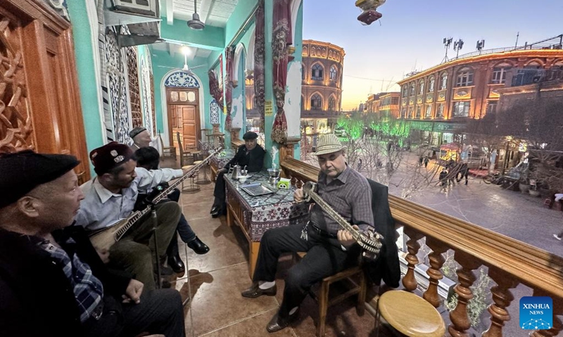 Local residents play musical instruments at a teahouse in the ancient city of Kashgar scenic area in Kashgar, northwest China's Xinjiang Uygur Autonomous Region, March 7, 2023. (Xinhua/Li Xiang)