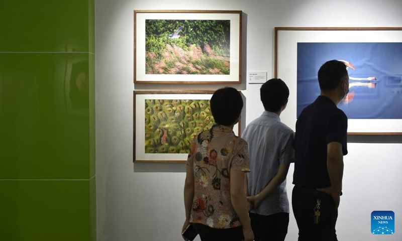 Visitors view photos at a photography exhibition during the 14th China Photography Festival in Sanmenxia City of central China's Henan Province, June 22, 2023. (Xinhua/Lu Peng)