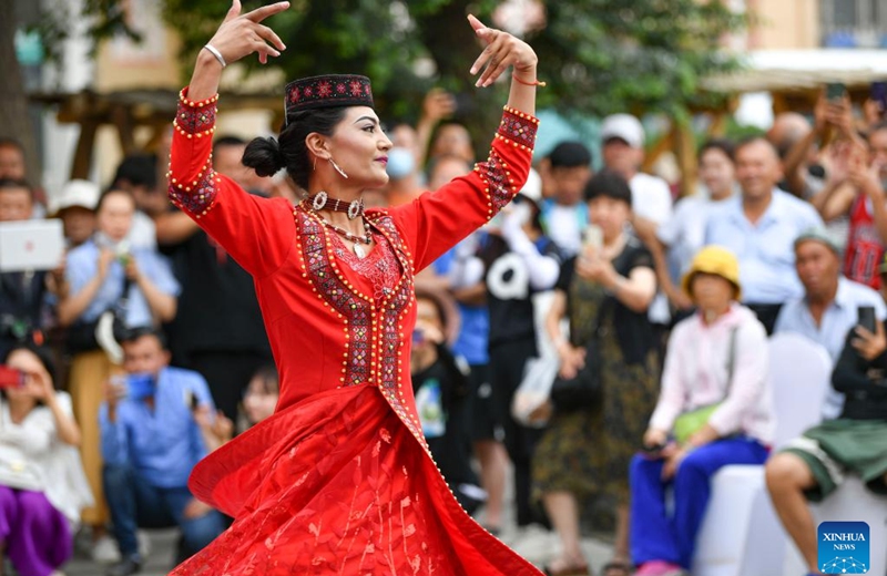An artist performs a show of intangible cultural heritage in the ancient city of Kashgar scenic area in Kashgar, northwest China's Xinjiang Uygur Autonomous Region, June 14, 2023. (Xinhua/Hu Huhu)