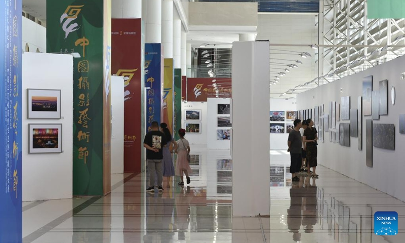 Visitors view photos at a photography exhibition during the 14th China Photography Festival in Sanmenxia City of central China's Henan Province, June 22, 2023. (Xinhua/Lu Peng)