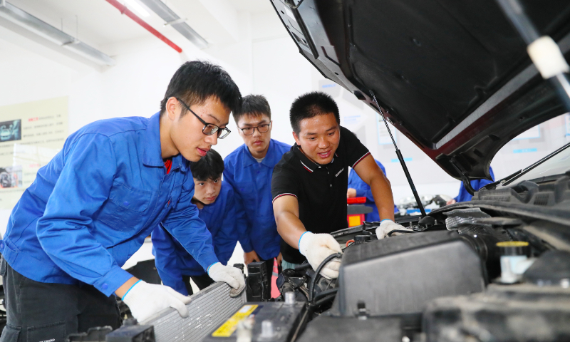 Students majoring in automotive application and maintenance conduct repair operations under the guidance of teachers at a secondary technical school in Yongzhou, Central China's Hunan Province on June 24, 2023. The school has cultivated and found jobs for more than 1,500 skilled talents with automakers through school-enterprise cooperation. Photo: VCG
