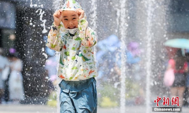 A boy cools himself at a fountain in Beijing, June 23, 2023. Beijing issued a red alert for high temperatures on Friday, the highest in China's alert system, as a scorching heatwave hit the city. The weather forecast predicts a prolonged battle against high temperatures in the following week. (Photo: China News Service/Jia Tianyong)
