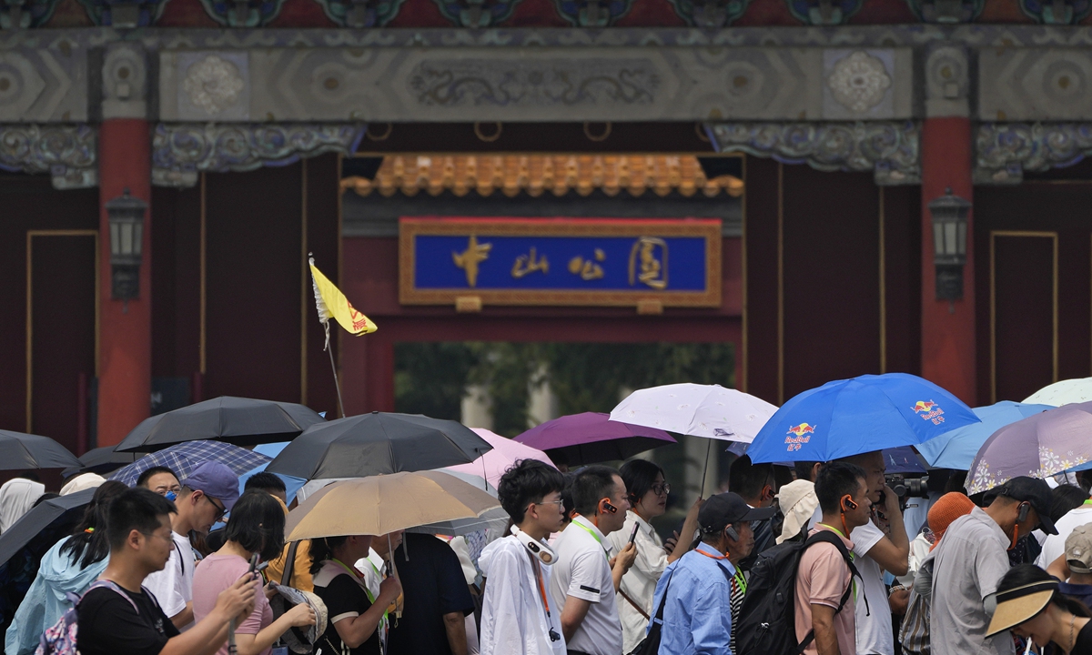 Tourists carrying umbrellas line up to enter the Forbidden City on a hot day in Beijing, June 25, 2023. Beijing and parts of northern China are experiencing record temperatures, and authorities urged people to limit their time outdoors during a long holiday weekend. Photo: VCG