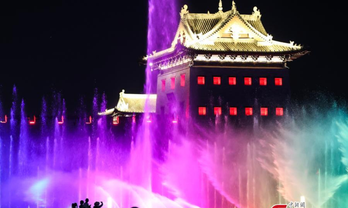 People beat the summer heat at night around a musical fountain in Datong, north China's Shanxi Province, June 29, 2023. Photo:Xinhua