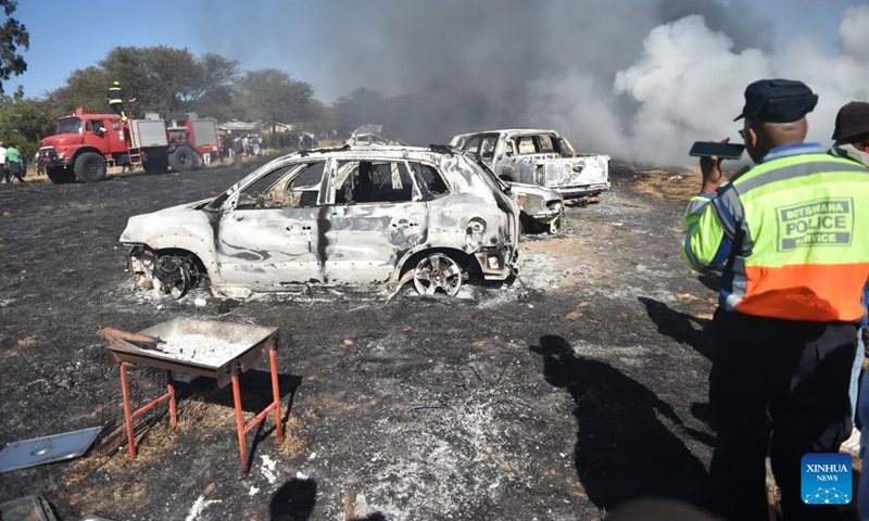 A police officer makes a phone call at the site where cars were burnt to ashes in Jwaneng mining town located about 165km west of Gaborone, Botswana, on June 25, 2023. Forty-nine vehicles caught fire in Jwaneng mining town Sunday afternoon in southern Botswana, where the owners were attending the 2023 Toyota Desert Race.(Photo: Xinhua)