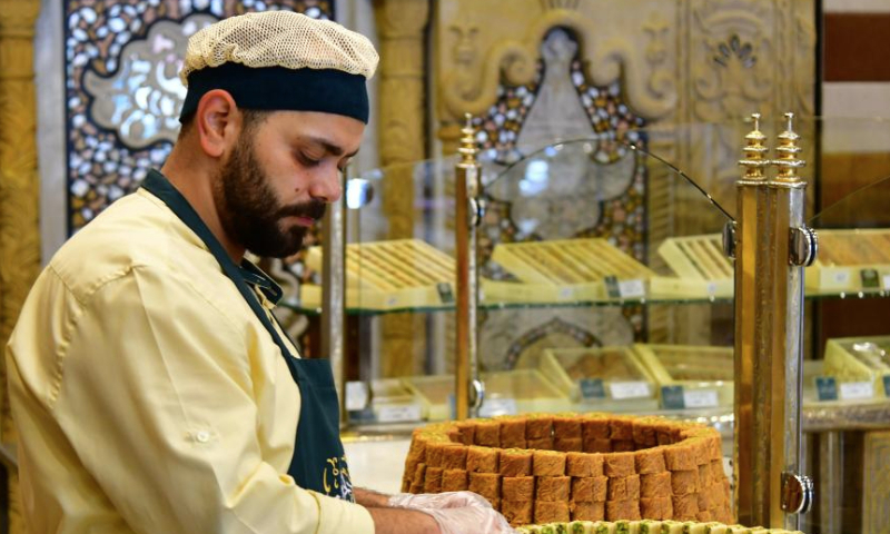 A sweet maker prepares special sweets for the upcoming Muslim festival of Eid al-Adha, or the Feast of Sacrifice, in Damascus, Syria, June 27, 2023. (Photo by Ammar Safarjalani/Xinhua)