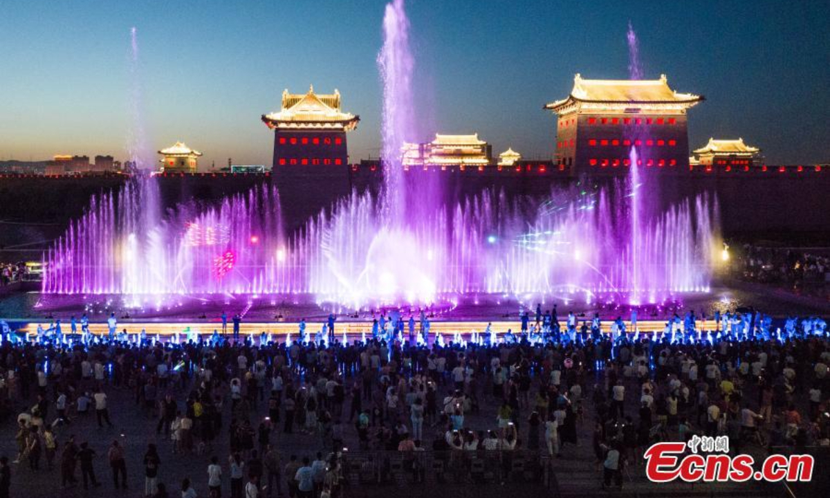 People beat the summer heat at night around a musical fountain in Datong, north China's Shanxi Province, June 29, 2023. Photo:Xinhua