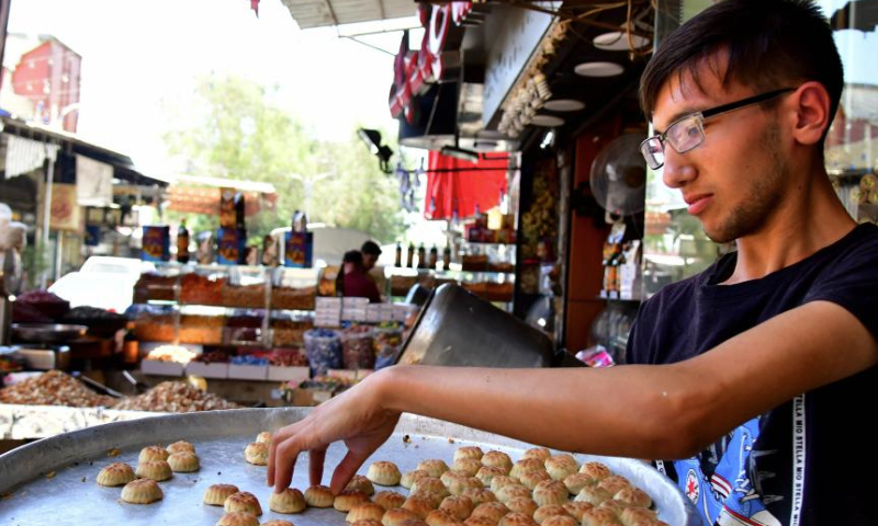 A sweet maker prepares special sweets for the upcoming Muslim festival of Eid al-Adha, or the Feast of Sacrifice, in Damascus, Syria, June 27, 2023. (Photo by Ammar Safarjalani/Xinhua)