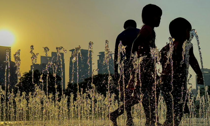 Children play at an artificial fountain to cool off in Sheraton hotel park in Doha, Qatar, on July 6, 2023. (Photo by Nikku/Xinhua)