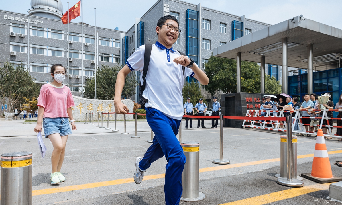 Students walk out of an exam site on the final day of the senior high school entrance exam on June 26, 2023, in Beijing, as parents wait at the school gate with flowers and gifts. Photo: Li Hao/GT