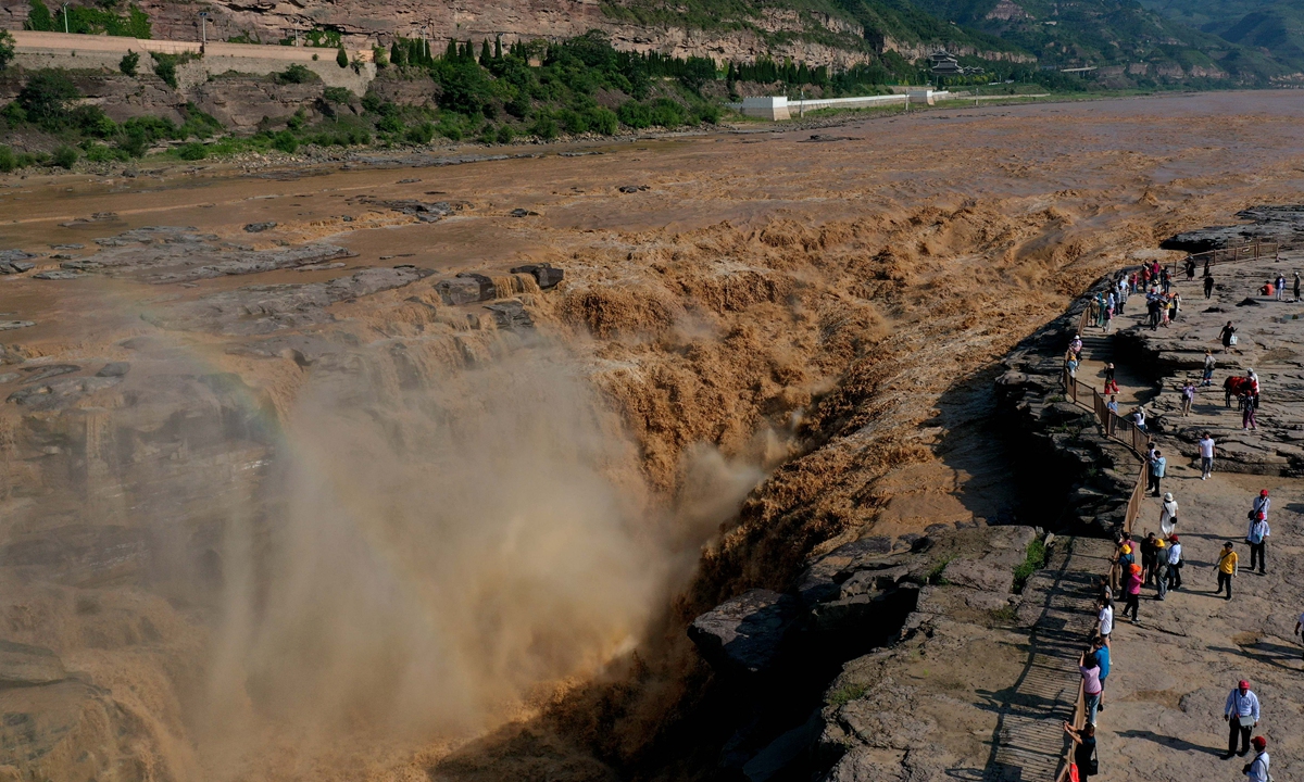 Tourists view the scenery at the Hukou Waterfall on the Yellow River in Linfen, North China's Shanxi Province on June 29, 2023. Located on the border between Shanxi and Northwest China's Shaanxi Province, the Hukou Waterfall is the largest waterfall on the Yellow River, the second largest waterfall in the country and the world's largest yellow waterfall. Photo: VCG