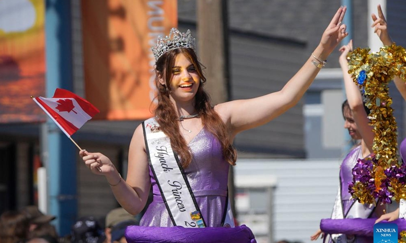 A participant waves from a float during the Salmon Festival Parade in Richmond, British Columbia, Canada, on July 1, 2023. (Photo by Liang Sen/Xinhua)