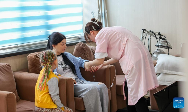 A nurse gives an intravenous infusion treatment to a Russian patient at a hospital in Hunchun, northeast China's Jilin Province, June 28, 2023. Hunchun is located at China's border with Russia and the Democratic People's Republic of Korea. Traditional Chinese medicine treatments such as acupuncture and Tuina remedial massage have drawn Russian tourists to the city.(Photo: Xinhua)
