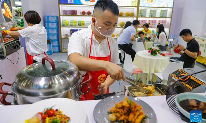 An exhibitor cooks chicken imported from Thailand at the Thailand pavilion of the Belt and Road International Cooperation Pavilion during the 19th Western China International Fair (WCIF) in Chengdu, southwest China's Sichuan Province, June 29, 2023. Kicking off here on Thursday, the five-day fair attracts more than 3,500 enterprises from 56 countries and regions(Photo: Xinhua)