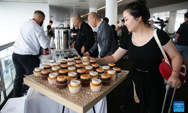 A passenger takes a cupcake at the Brussels Airport in Zaventem, Belgium, June 28, 2023. A ceremony was held for China's Hainan airlines at Brussels Airport on Wednesday to mark the resumption of its Brussels-Shenzhen direct flights.(Photo: Xinhua)