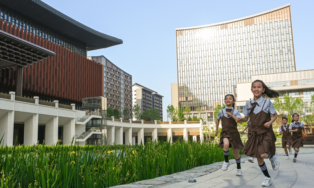 Children run in front of the business and service convention center in Xiong'an on May 15, 2023. Photo: Chen Tao/GT
