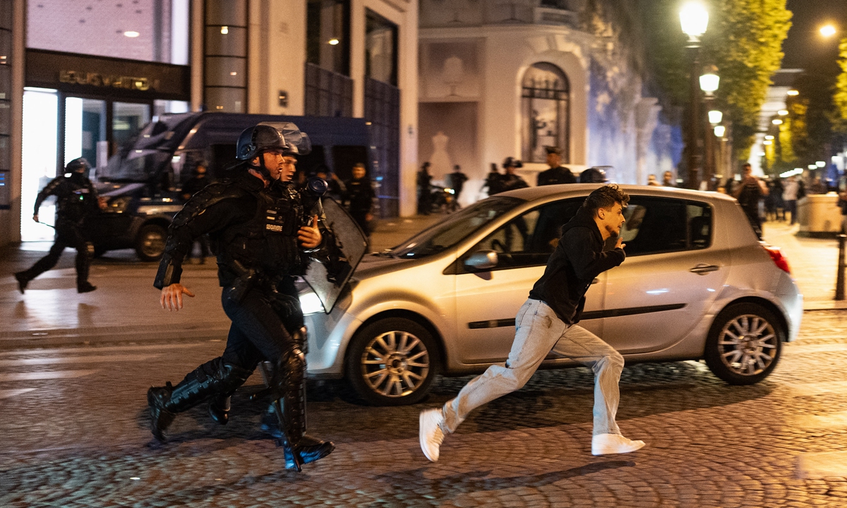 On the Champs Elysees, France, a demonstrator tries to escape from the police on June 29. Photo: AFP