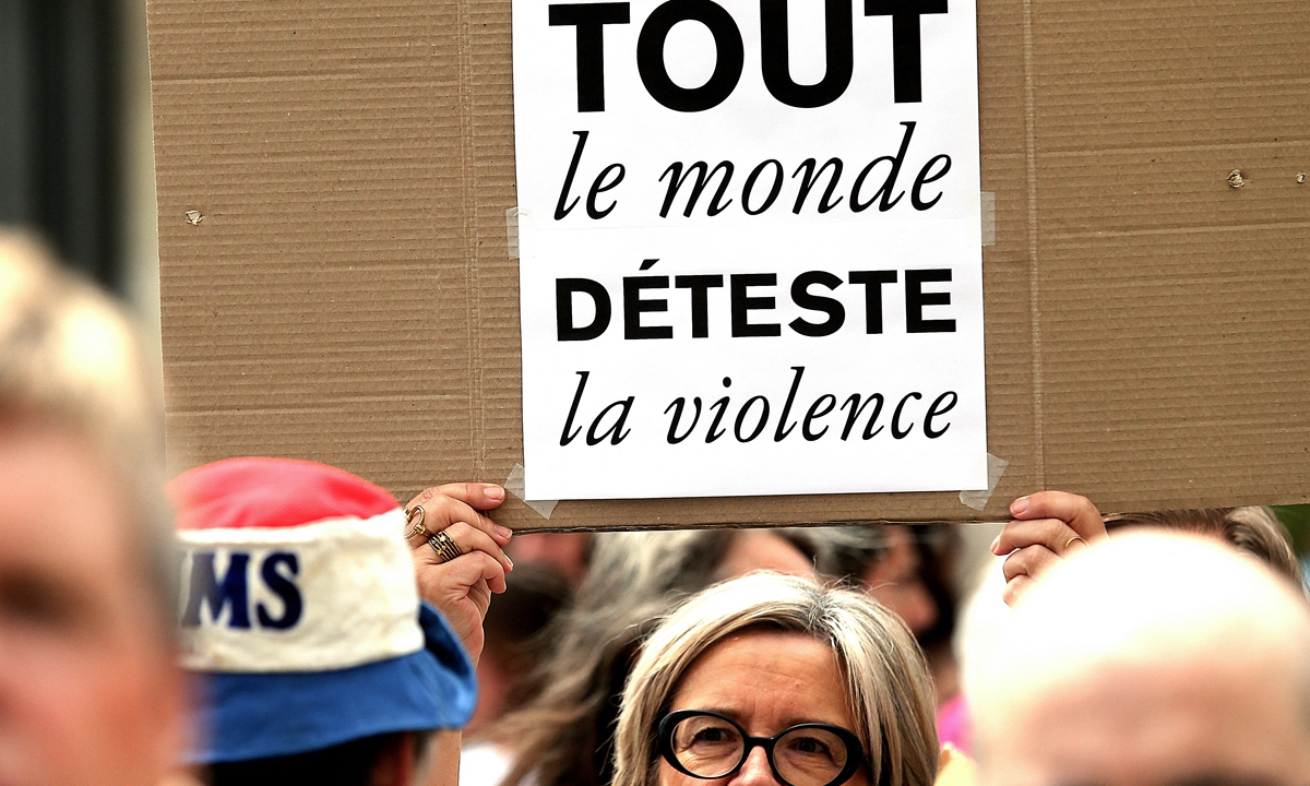 A woman holds up a placard that reads everyone hates violence as participants take part in a nationwide action in Reims, northern France, on July 3, 2023, after France's mayors have called on the population and elected representatives to gather in front of all town halls at midday, invoking civic mobilization following the violent attack on the home of the mayor of L'Hay-les-Roses (Val-de-Marne), which sparked a wave of indignation across the country.Photo: AFP