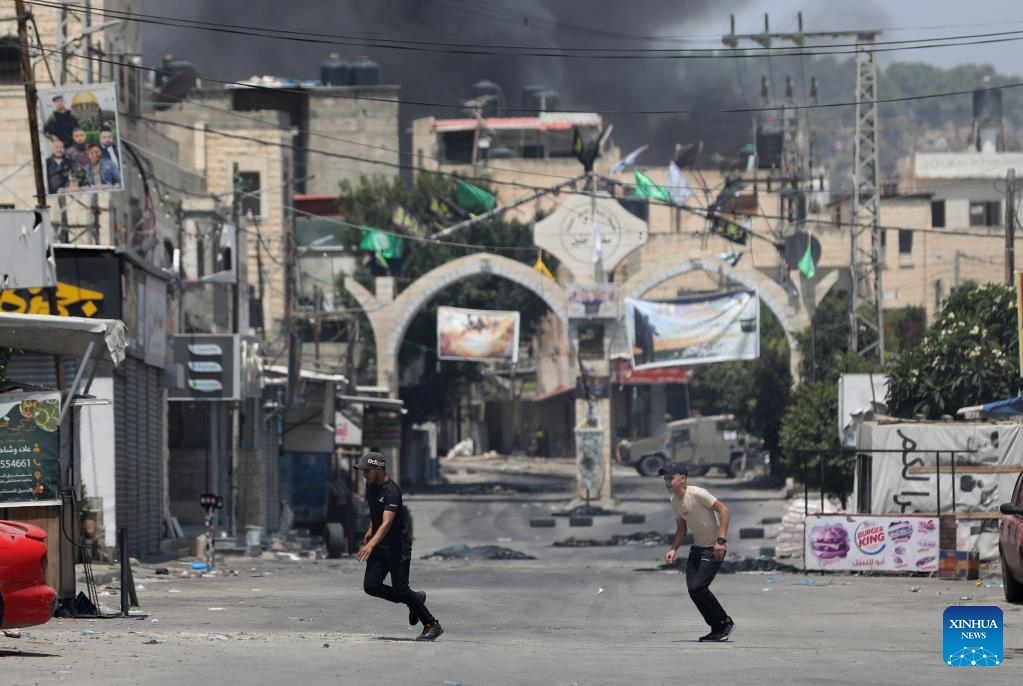 Palestinians run to take cover during clashes between Palestinians and Israeli forces in the West Bank city of Jenin, on July 3, 2023. At least eight Palestinians were killed and dozens were injured in Jenin on Monday during the Israeli operation launched from midnight throughout the day, said the Palestinian Health Ministry. Photo: Xinhua