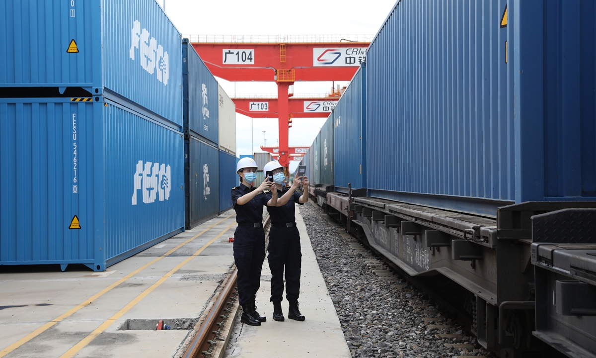 Two customs officials from the port inspect the train as it departs from the station on July 4, 2023. Photo: Courtesy of Guangzhou Customs