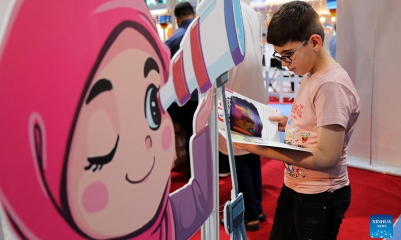A child reads a magazine during the second edition of the International Festival for Iraqi Children at the Baghdad International Fair in Baghdad, Iraq, on July 2, 2023. The ten-day festival will last till July 3.(Photo: Xinhua)