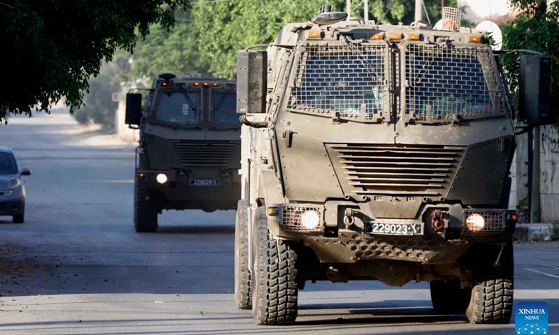 Israeli military vehicles drive through a refugee camp in the West Bank city of Jenin on July 3, 2023. The Israeli army launched a large-scale military strike early on Monday on the northern West Bank city of Jenin, according to eyewitnesses and the Israeli military.(Photo: Xinhua)
