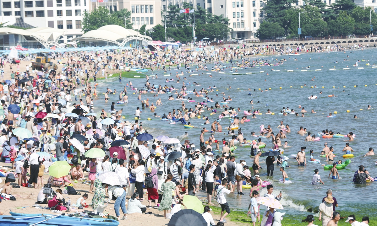 People relax at a beach in Qingdao, East China's Shandong Province on July 5, 2023. From July 5 to 10, some parts of northern China will continue to experience heat wave, with the highest temp reaching 40 C or above. Photo: IC